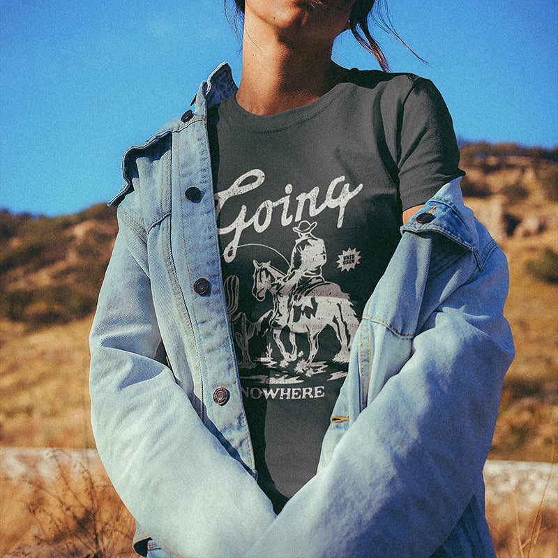 Model wearing Going Nowhere tee in desert with denim jacket — boho cowgirl outfit
