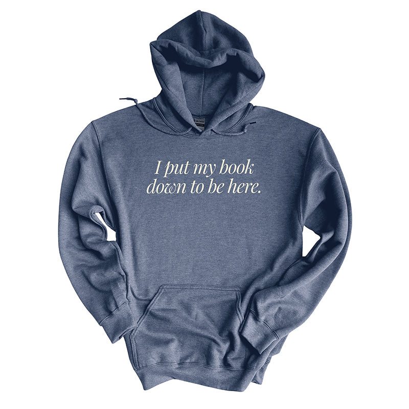 Flat lay of heather dark navy “I Put My Book Down To Be Here” hoodie – cozy unisex book lover pullover