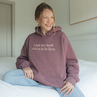 Woman wearing heather dark maroon “I Put My Book Down To Be Here” hoodie – cozy sarcastic hoodie for readers who’d rather be home reading