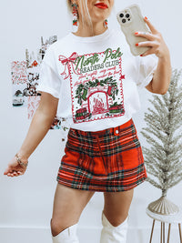 Heavyweight vintage-style Christmas tee for book lovers — North Pole Readers Club design with greenery and fireplace