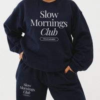Model wearing matching navy Slow Mornings Club sweatshirt and sweatpants lounge set