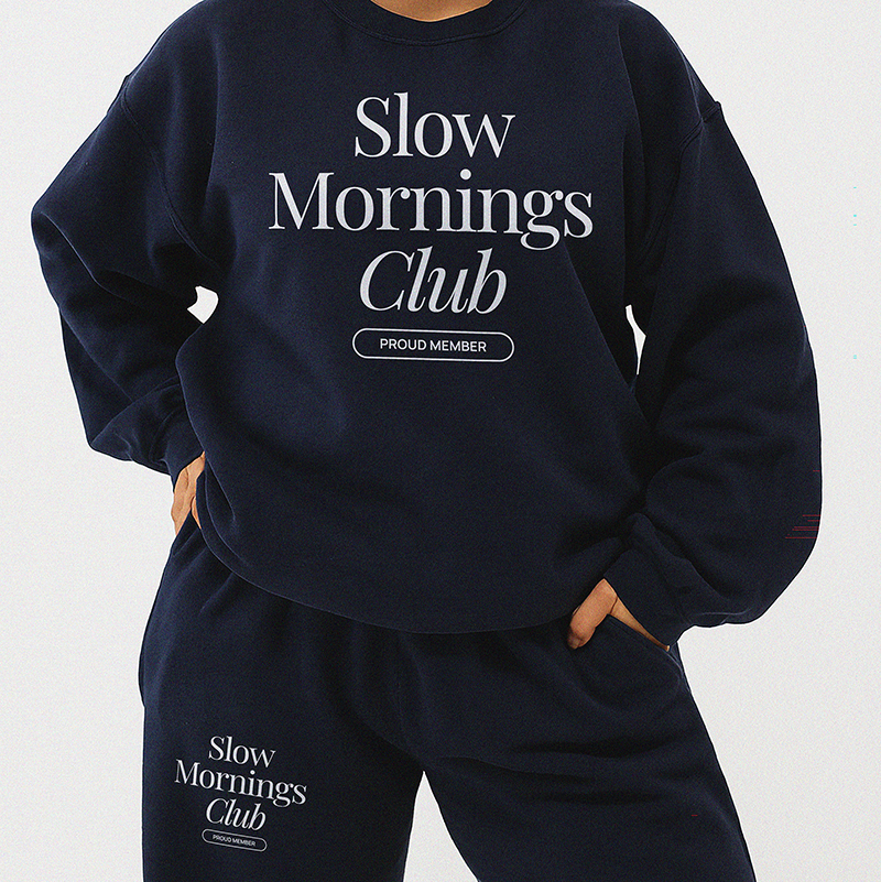 Model wearing matching navy Slow Mornings Club sweatshirt and sweatpants lounge set