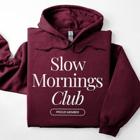 Flatlay of maroon Slow Mornings Club hoodie with Slow Mornings Club print