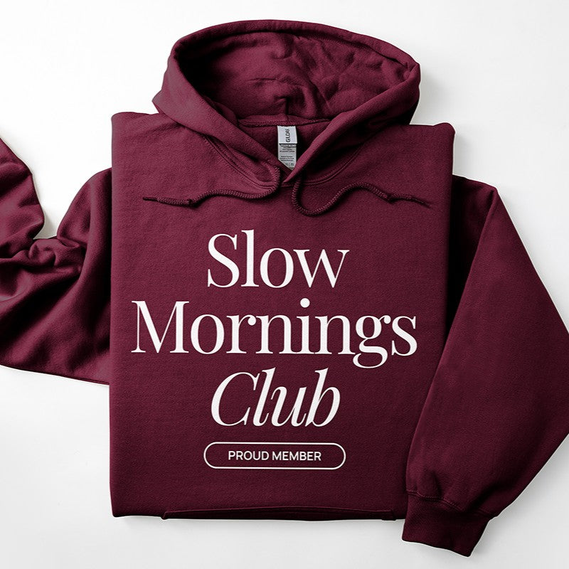 Flatlay of maroon Slow Mornings Club hoodie with Slow Mornings Club print