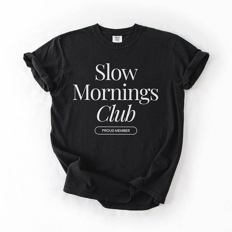 Flatlay of black Slow Mornings Club Tee with minimalist ‘Proud Member’ graphic