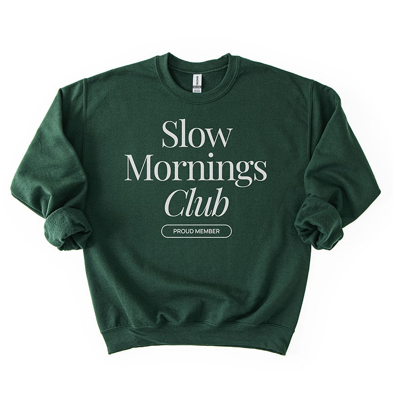 Flatlay of forest green Slow Mornings Club crewneck sweatshirt with minimalist graphic