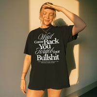 Woman wearing the Wait Come Back You Forgot Your Bullshit graphic tee in black – bold white typography on heavyweight Comfort Colors shirt.